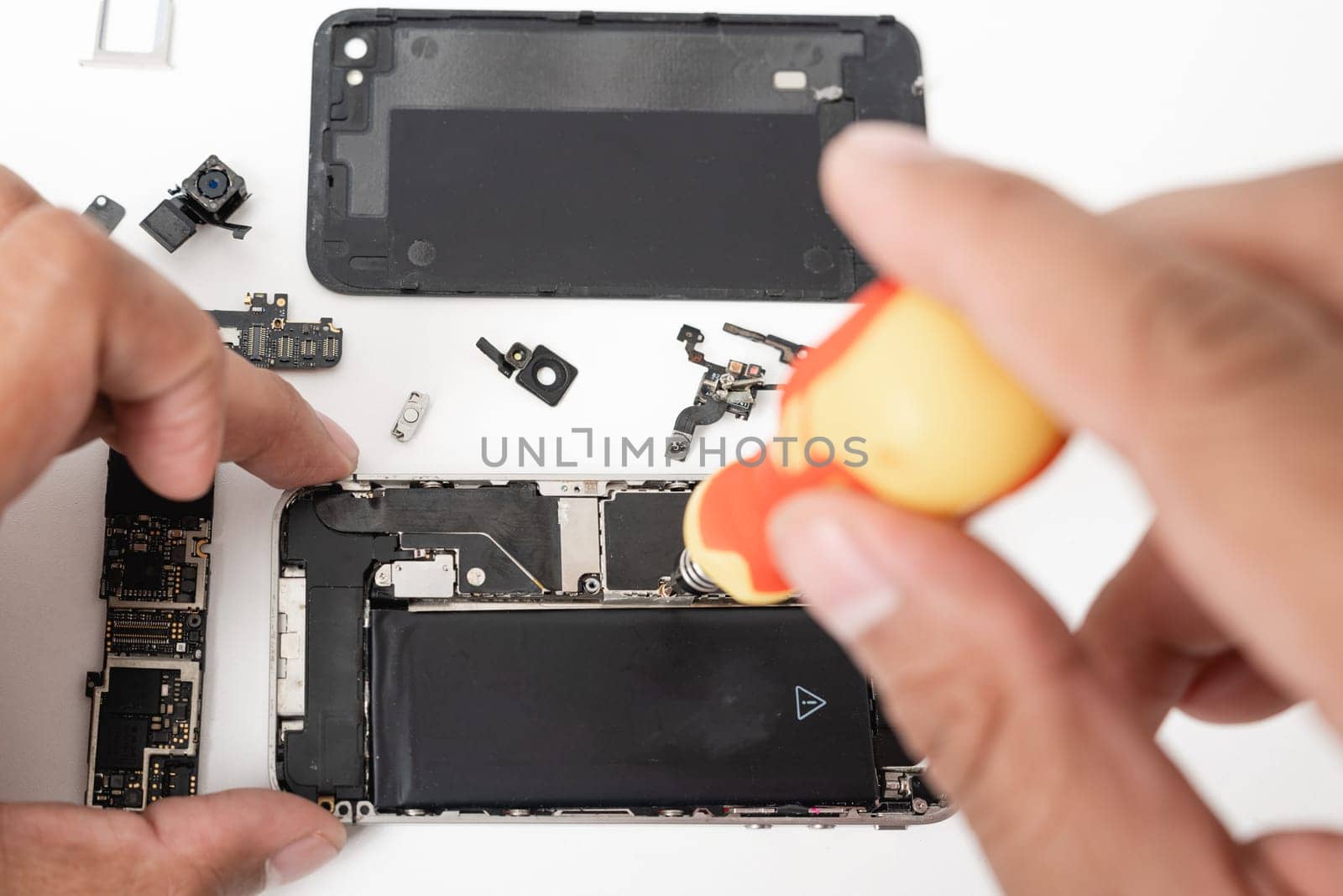 Technician repairing inside the smartphone motherboard with tools for recovery, The man repair by tightening nut from mobile phone with a screwdriver to fix problem