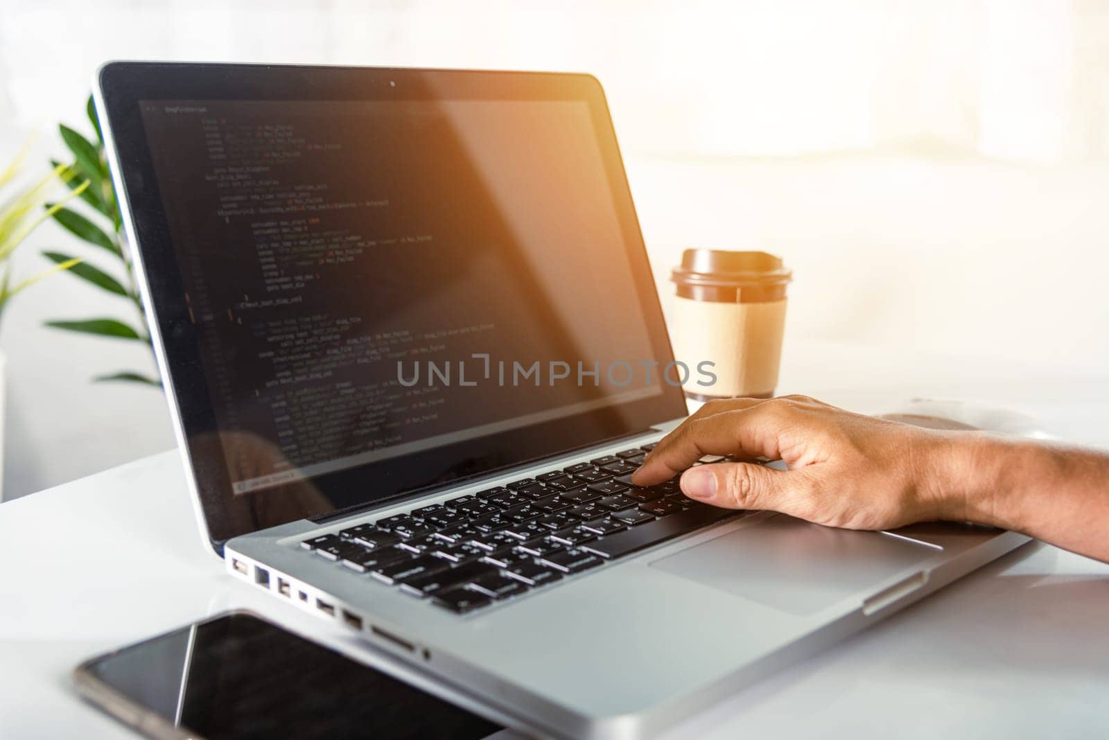 Web application development. programmer woman writing program code sitting at workplace in office, software developer hands coding HTML programming with laptop computer, IT start up concept, back view