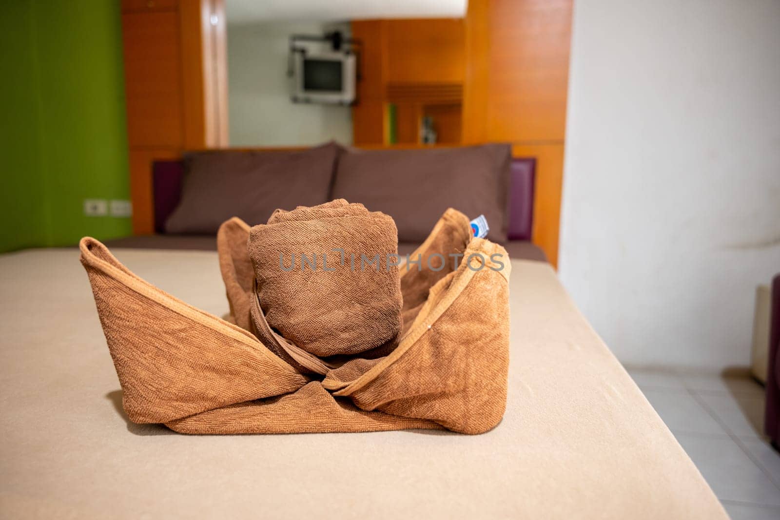 Yellow towel on bed decoration in bedroom interior, Freshly laundered fluffy towels, Towel in hotel room, Beautifully folded toiletries