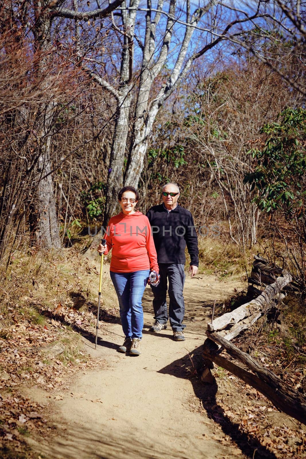 Senior couple is hiking in the woods in North Carolina in fall