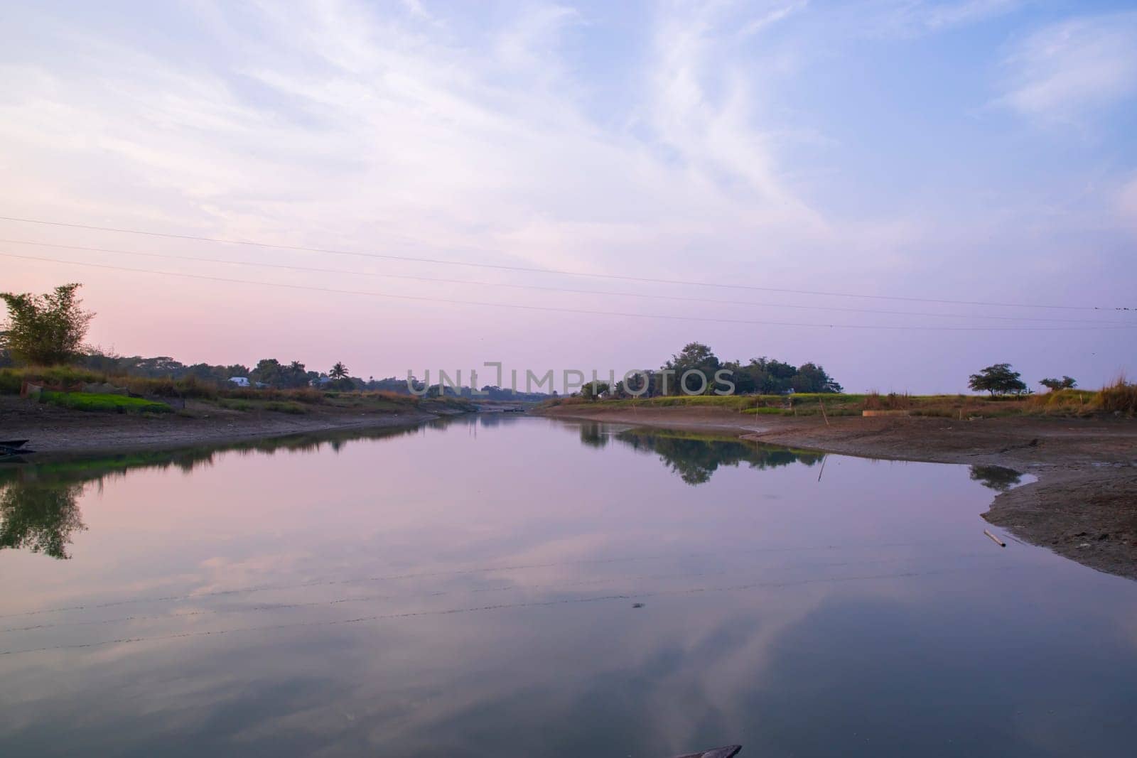 Arial View Canal with green grass and vegetation reflected in the water nearby Padma river in Bangladesh