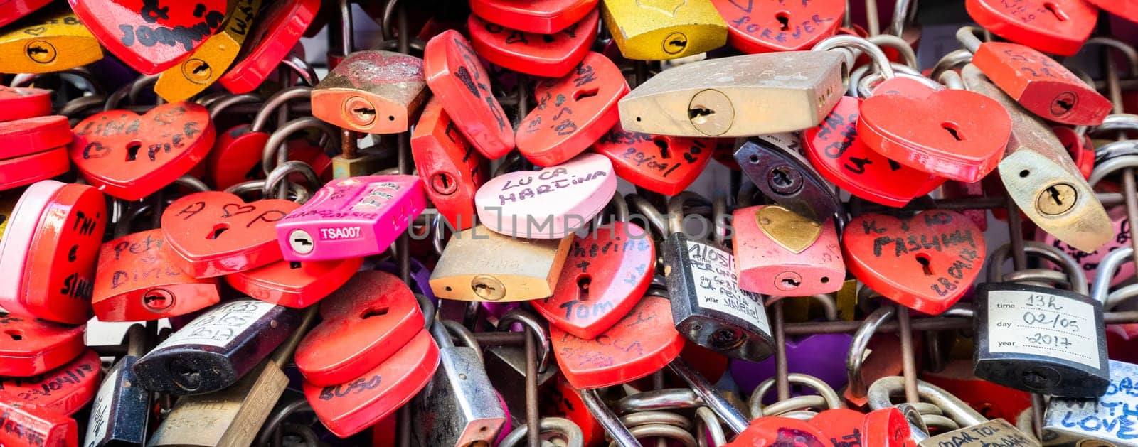 Verona, Italy - June 2022: background of heart-shaped locks on a wall, symbol of love forever
