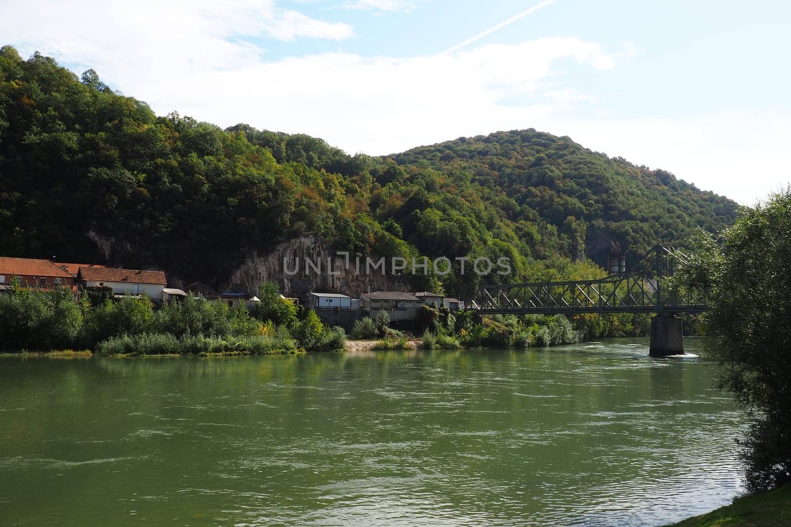 Mali Zvornik, Serbia, September 29, 2022. Drina river near Banja Koviljaca, view of the coast of Serbia from BiH. The flow of water, greenery on the opposite bank of the river. Residential houses
