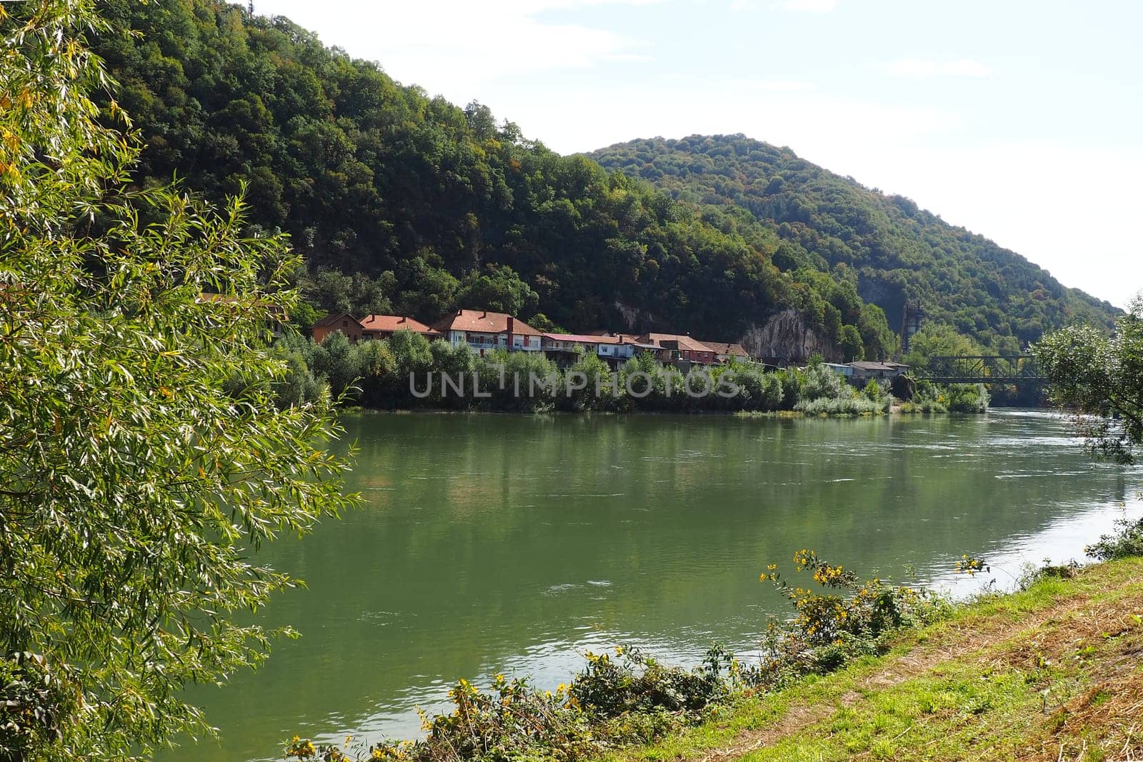Mali Zvornik, Serbia, September 29, 2022. Drina river near Banja Koviljaca, view of the coast of Serbia from BiH. The flow of water, greenery on the opposite bank of the river. Residential houses