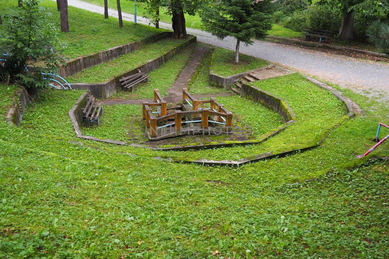 Banja Koviljaca, Loznica, Serbia. Mount Guchevo, park and forest. Source of mineral sulfuric and ferruginous water Rakina Chesma Cesma. A spring near the road to Guchevo. Concrete fence and stairs