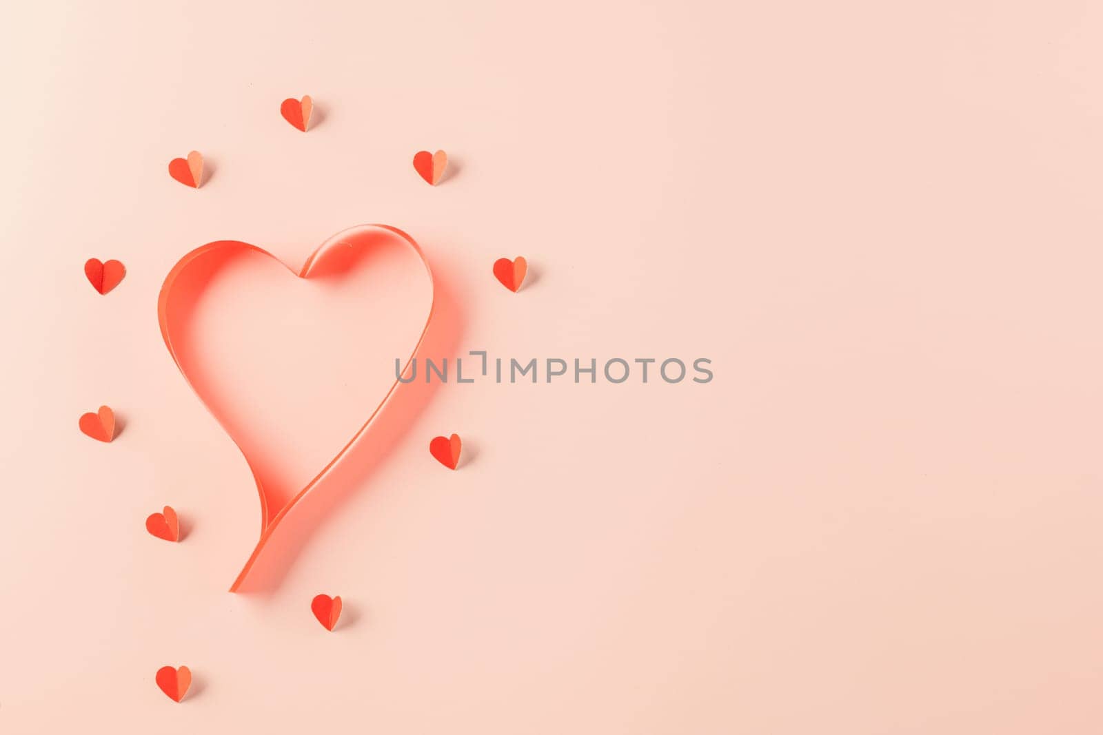 Love and Valentines Day background. Top view flat lay of Ribbons shaped as heart and paper elements cutting red hearts flying on pink background, Banner template greeting card design of holiday