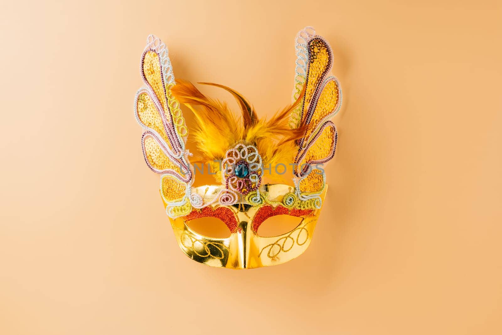 Happy Purim carnival decoration. Golden venetian ball mask, carnival mask isolated on pastel background, Purim or Mardi Gras in Hebrew, Masquerade party event
