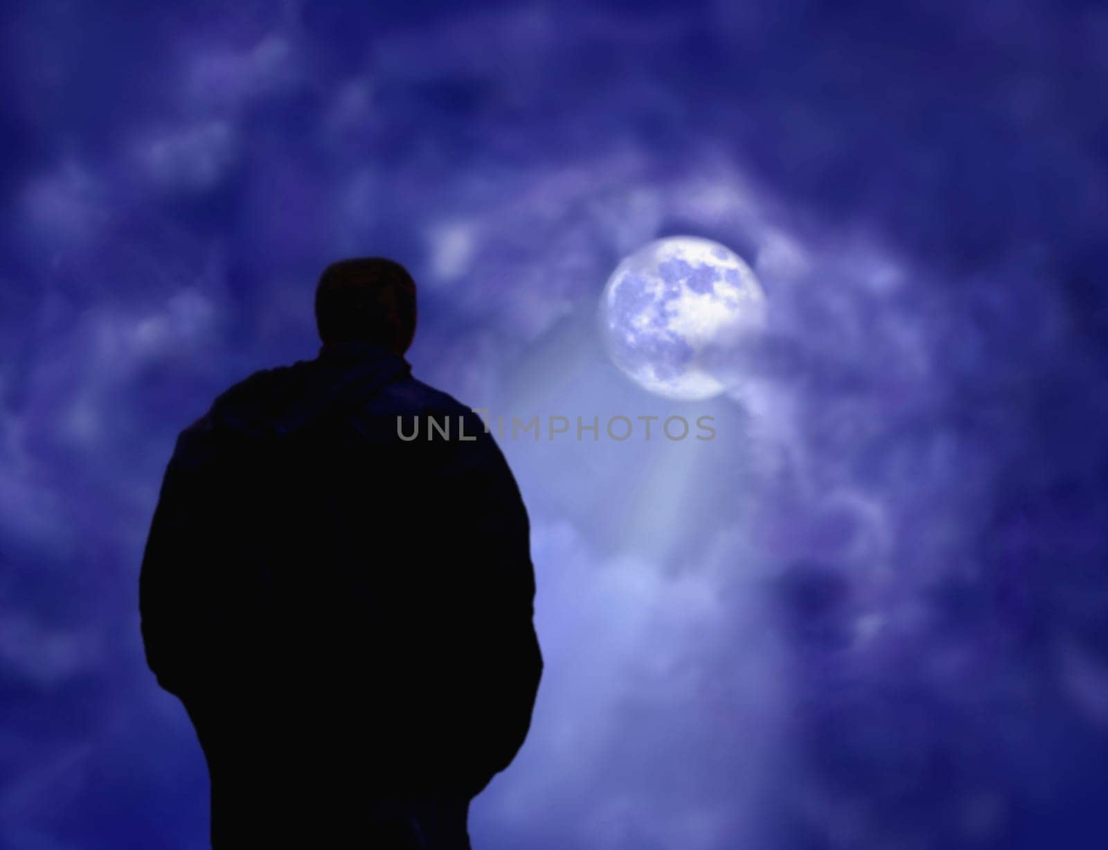 A man deep in thought looking at the moon.