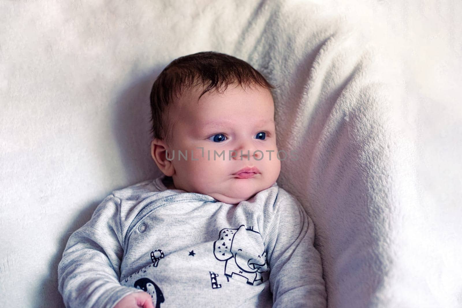 portrait of a cute European newborn baby with blue eyes on a white background