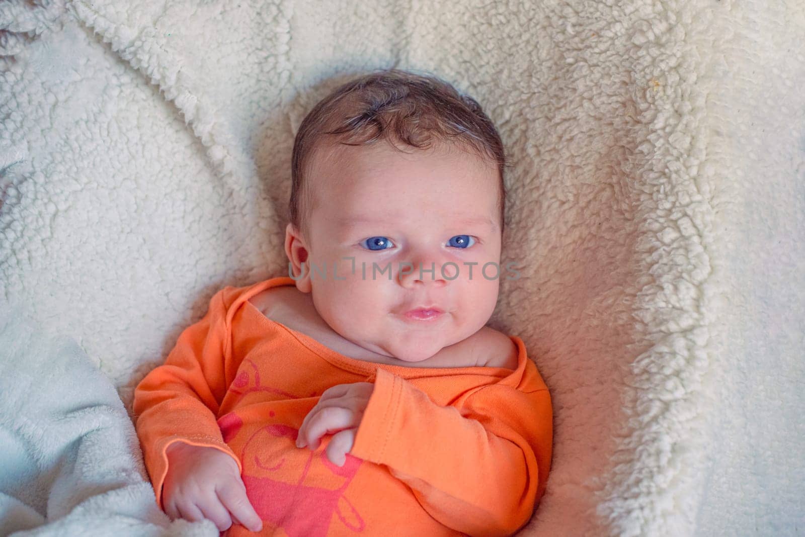 Newborn european white baby in orange clothes