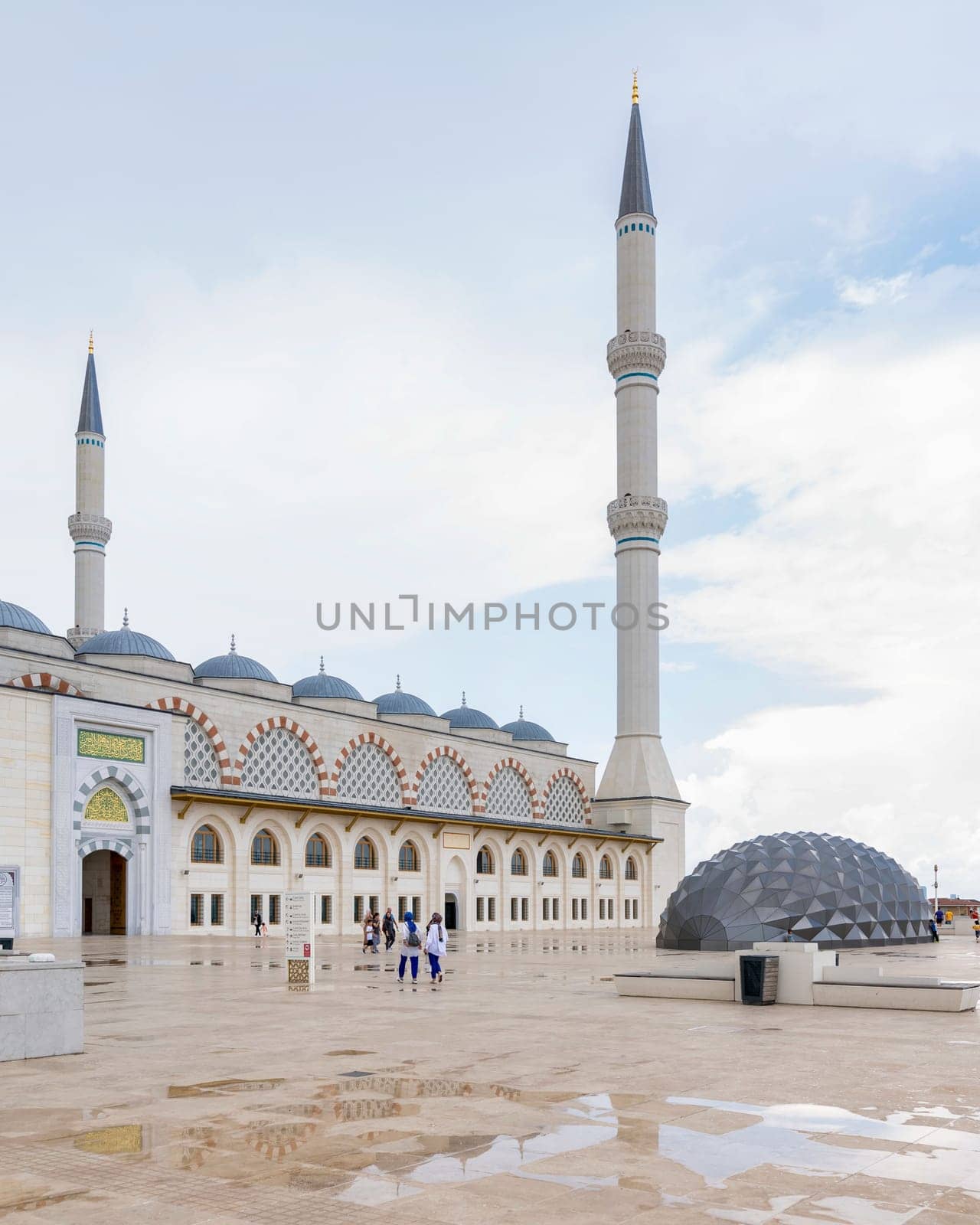 Istanbul, Turkey - August 31 2022: Side shot of Grand Camlia Mosque, or Buyuk Camlica Camii, with few pedestrians, a modern complex for Islamic worship, built in 2019, located in Camlica hill, Uskudar
