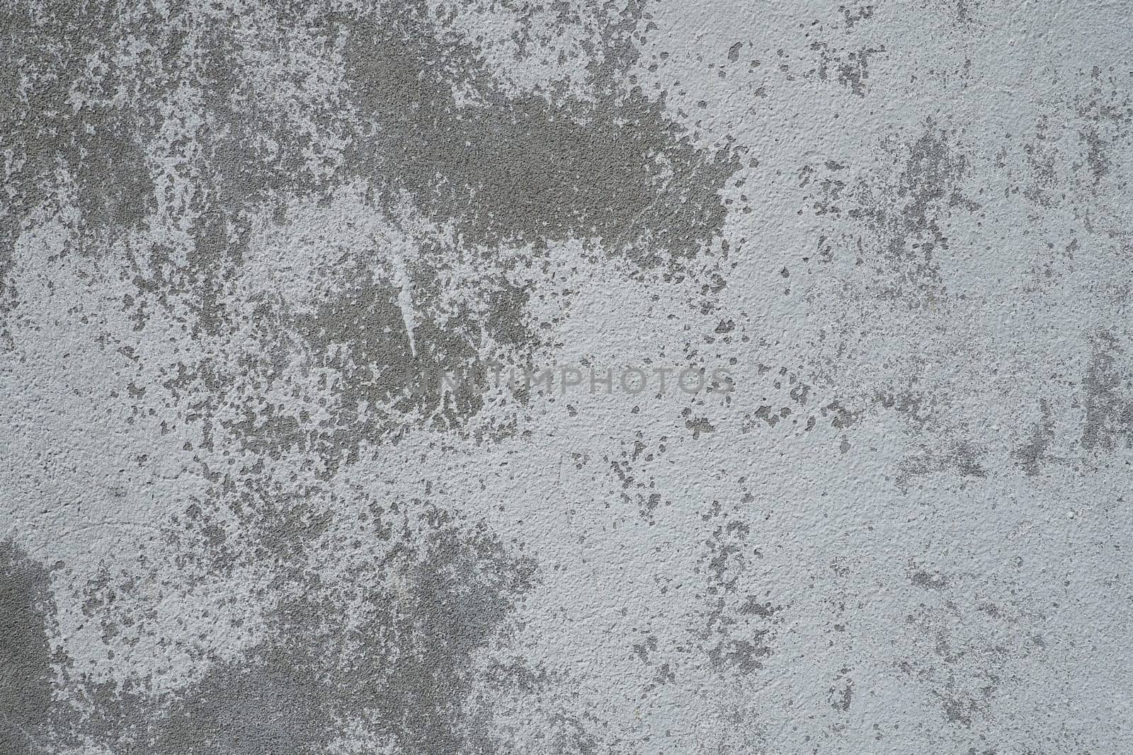 Plastered wall texture. Whitewash surface. Abstract background. Retro wall built structure texture. Cracks and bumps on the concrete wall. Uneven coloring with water-based paint. Old tattered plaster.