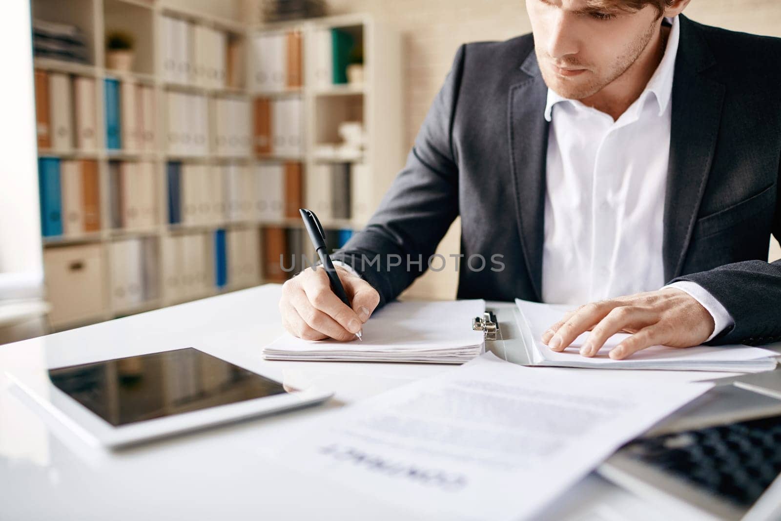 Male employee writing business plan at workplace
