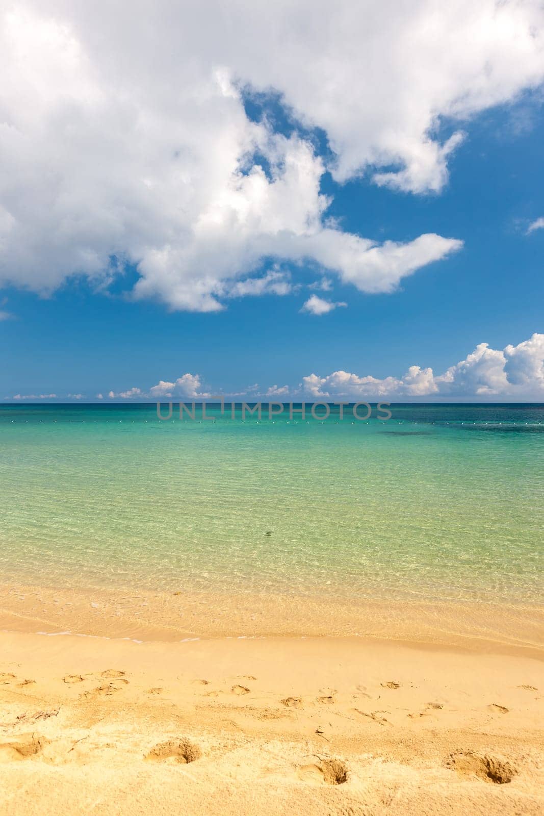 Beach on the tropical island. Clear blue water, sand and clouds. Beautiful vacation spot.