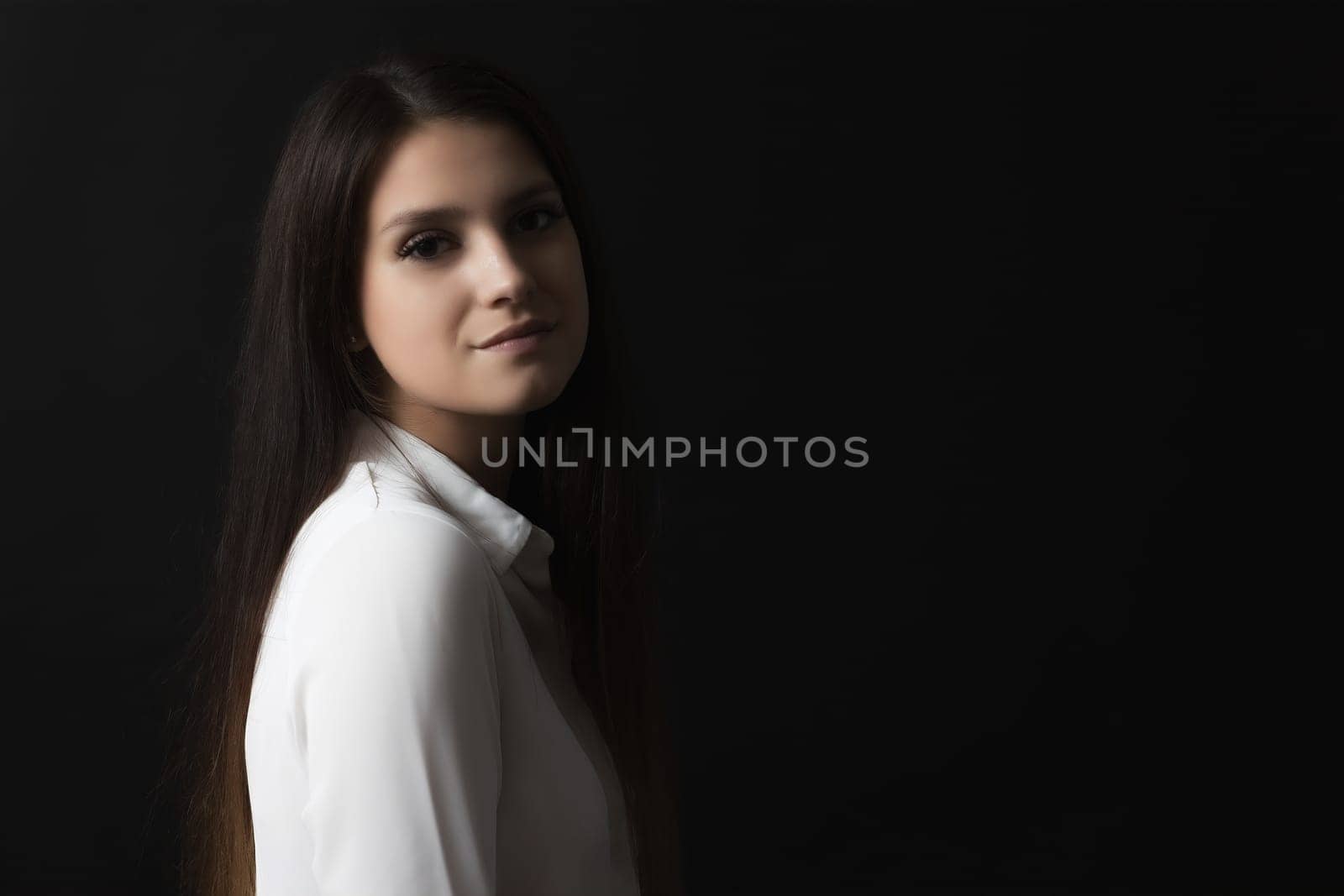 Low key side view portrait of beautiful long haired girl.
