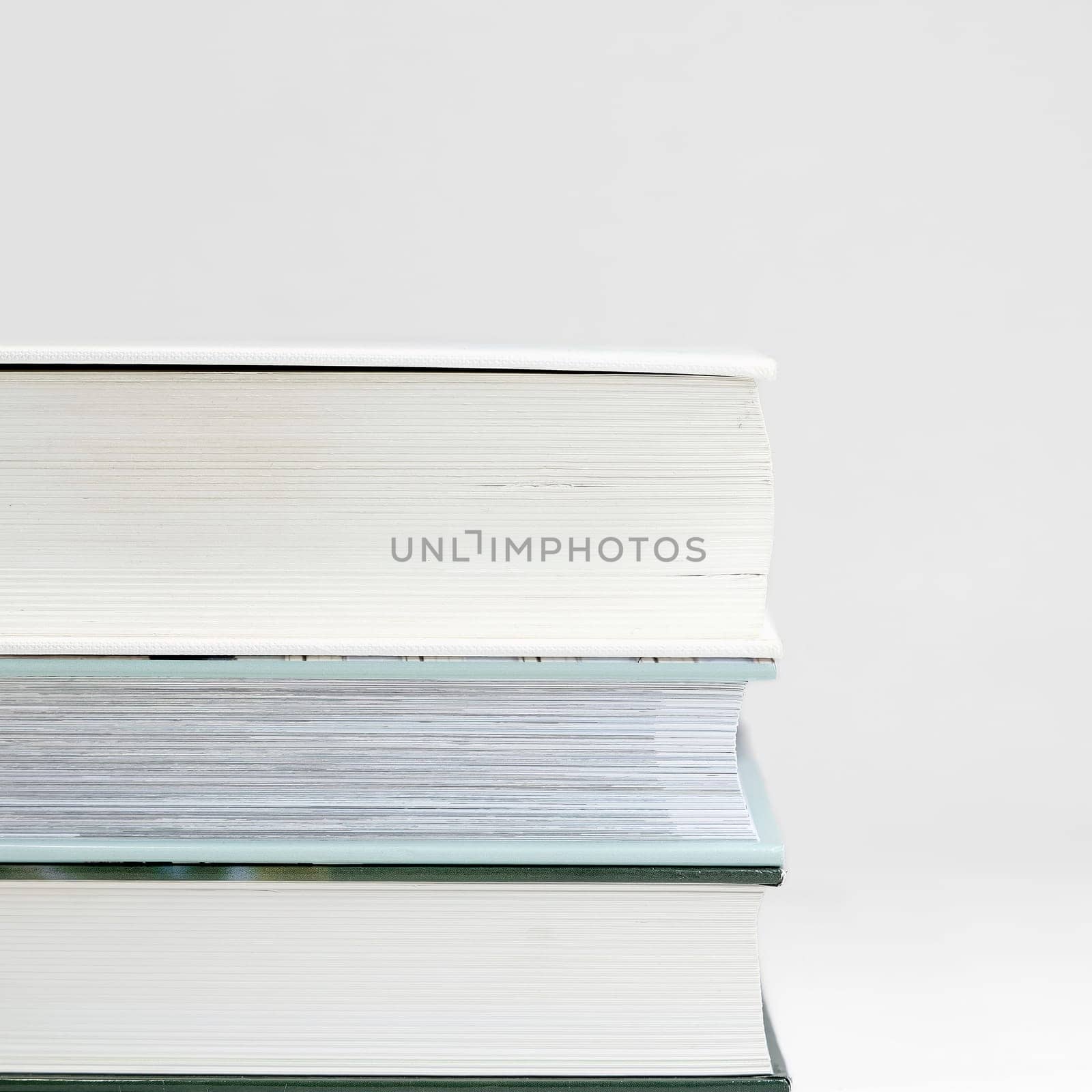 three thick books on a table with a white background