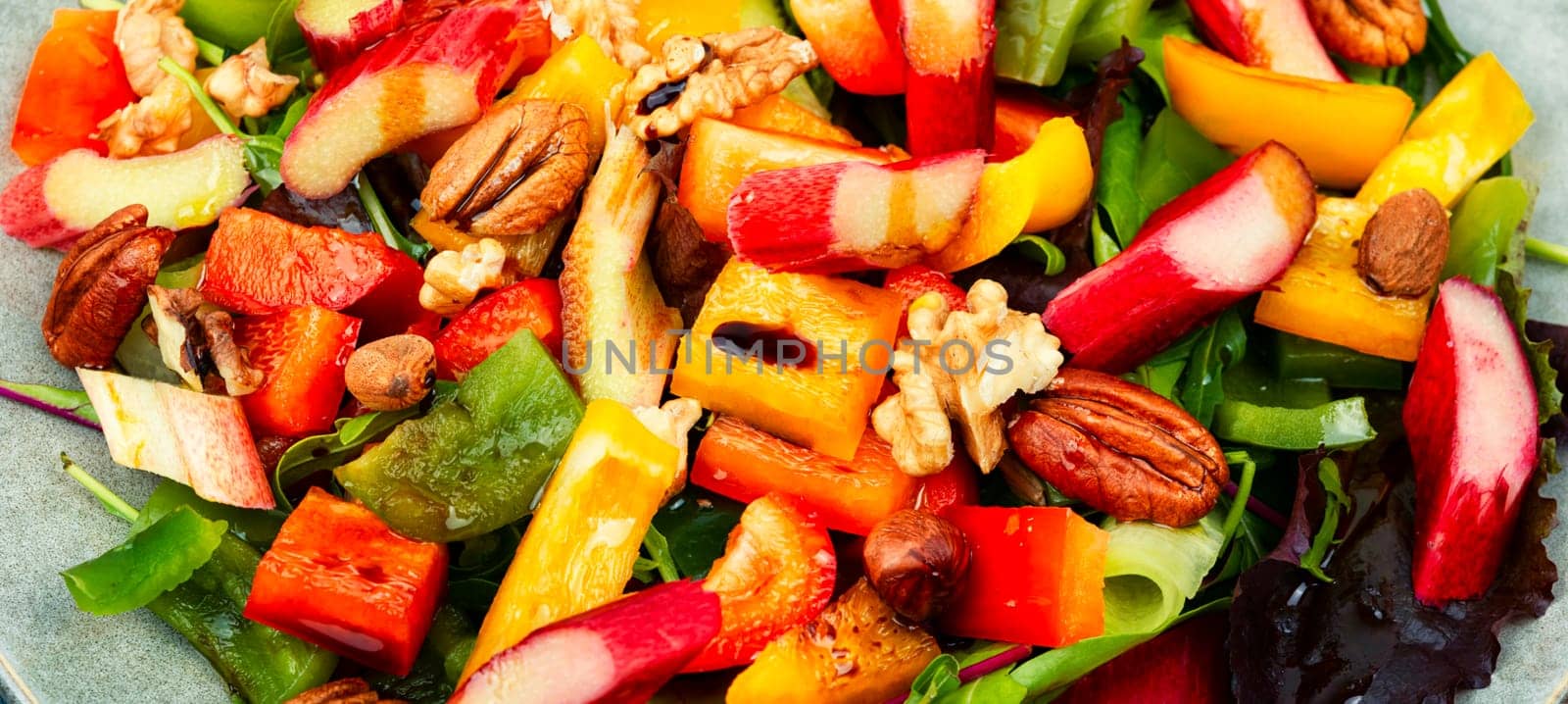 Vitamin delicious salad of rhubarb, bell pepper, herbs and nuts in bowl. Space for text