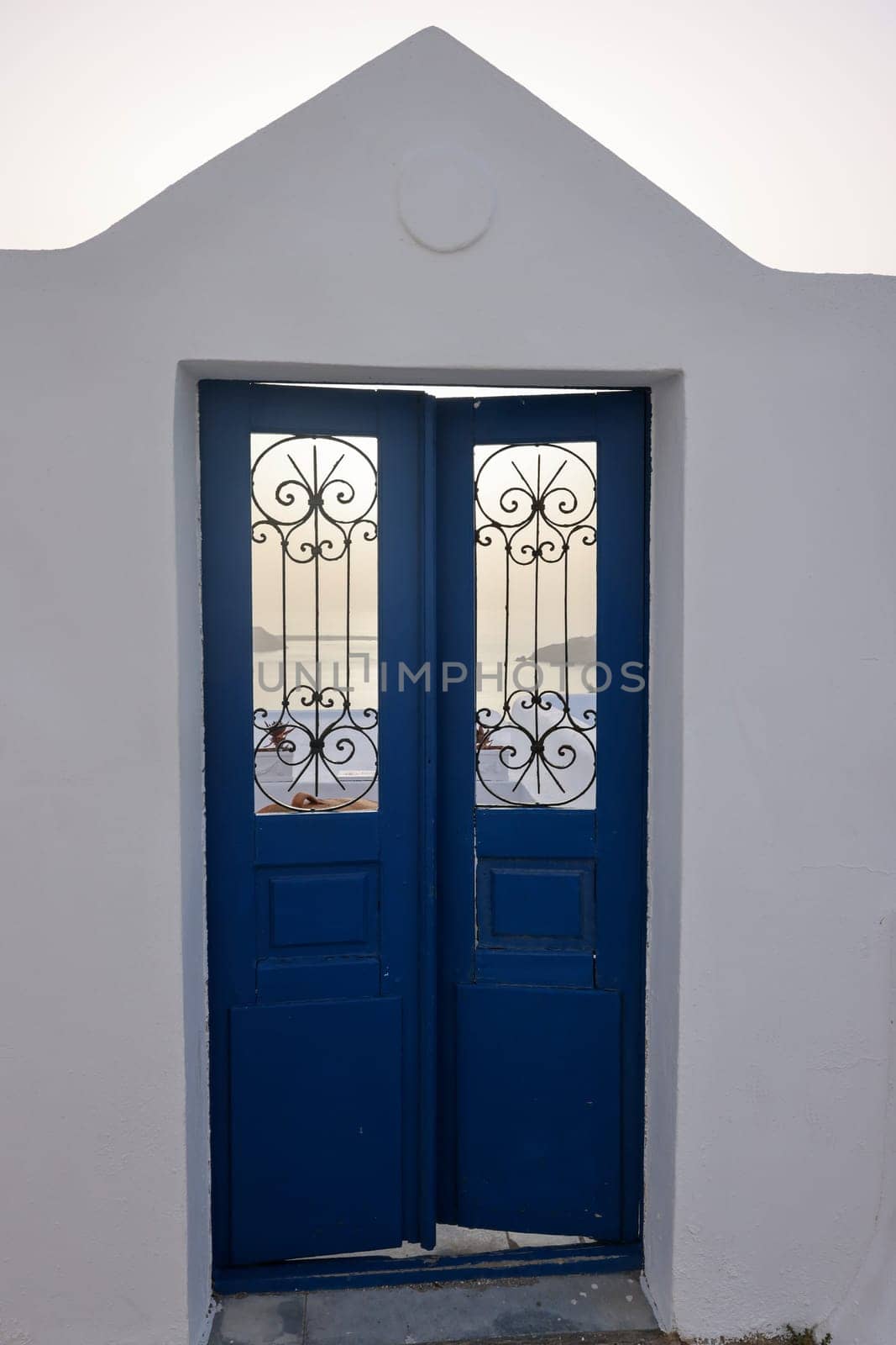 Closed blue door, a traditional piece of architecture on the island of Santorini. Greece