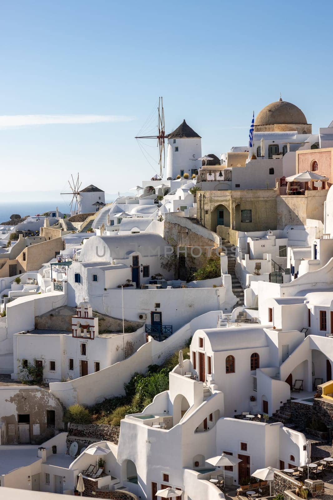 Oia, Santorini, Greece - June 28, 2021: Whitewashed houses and windmills in Oia on Santorini island, Cyclades, Greece
