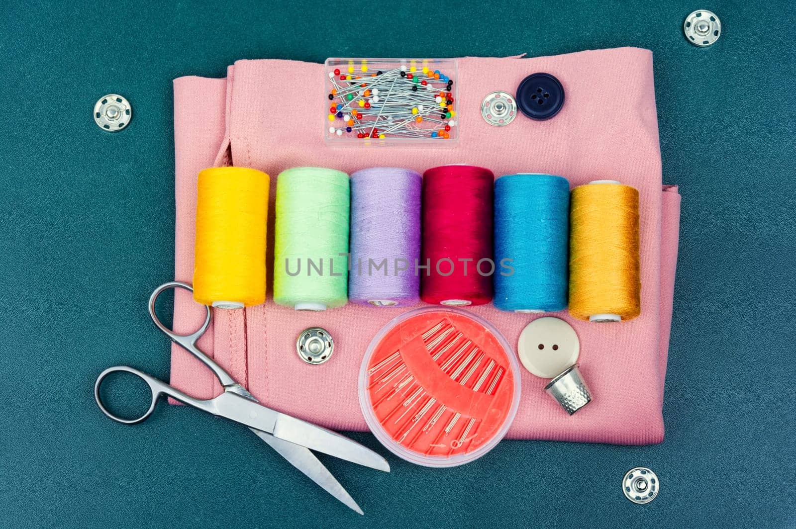 Home needlework kit, scissors, needles, buttons and bobbins with thread