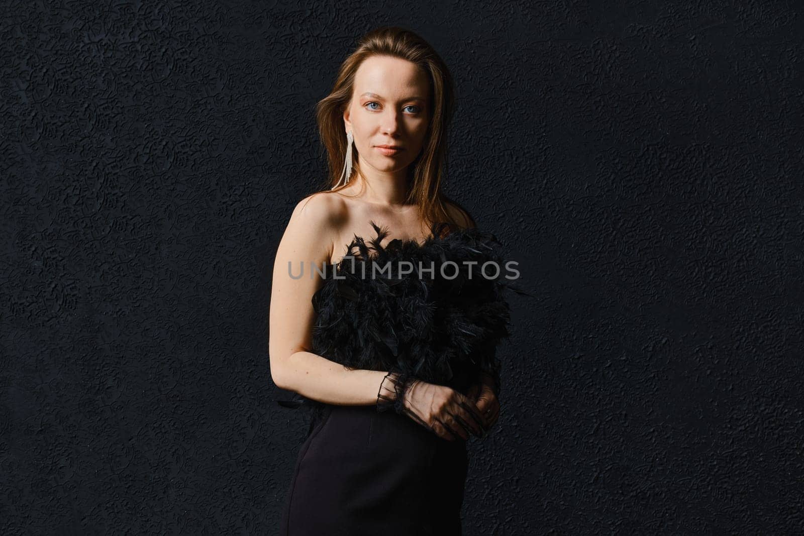 Low key photo of elegant woman in corset posing on black background