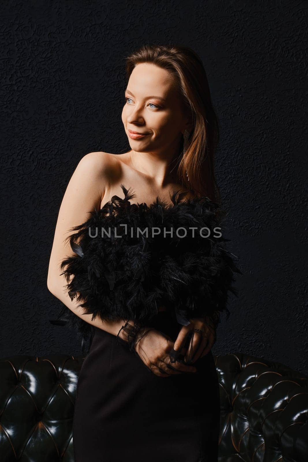 Low key portrait of positive charming woman over black background