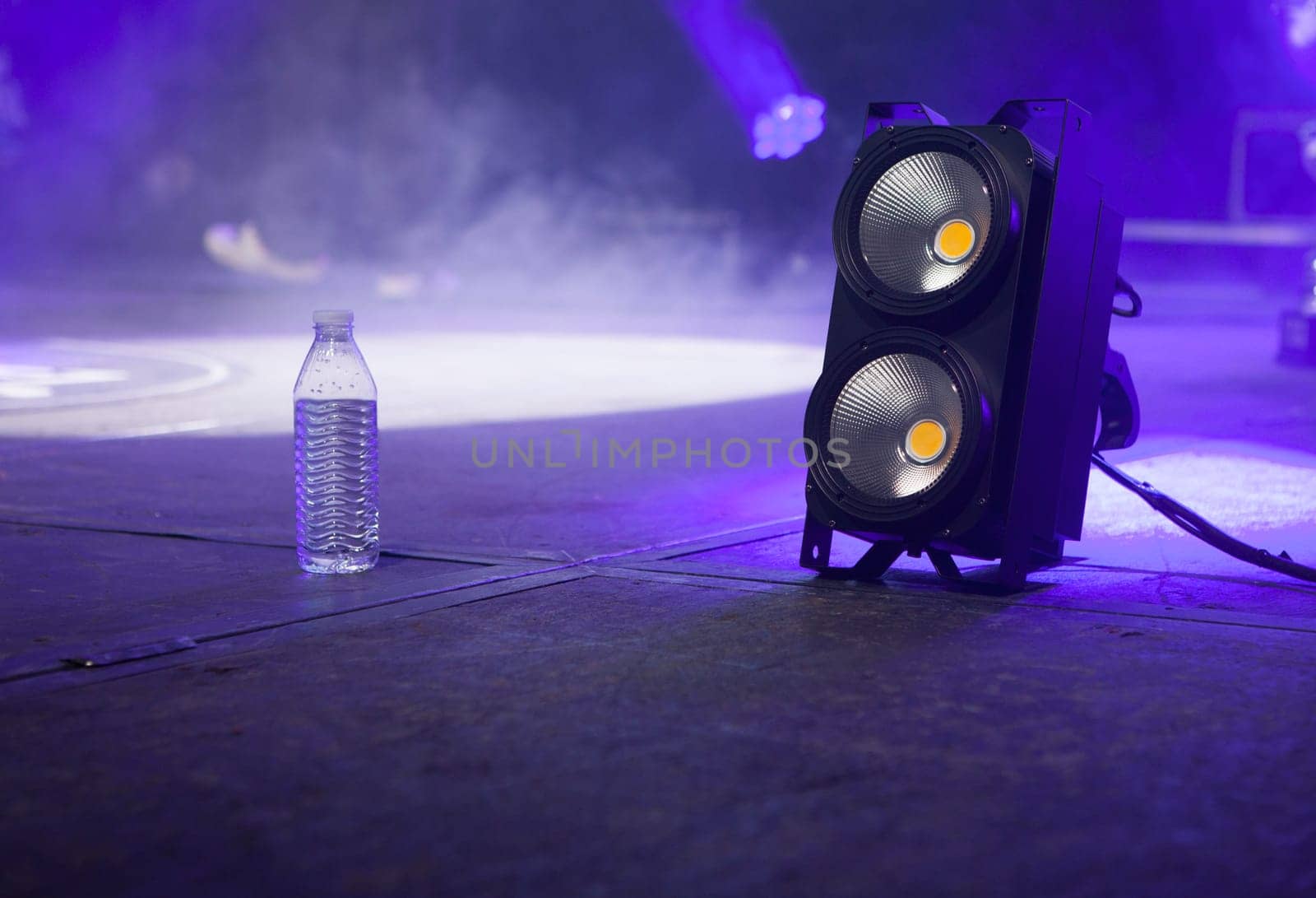 Bottle of water over stage beside light .stage blinder. Selective focus
