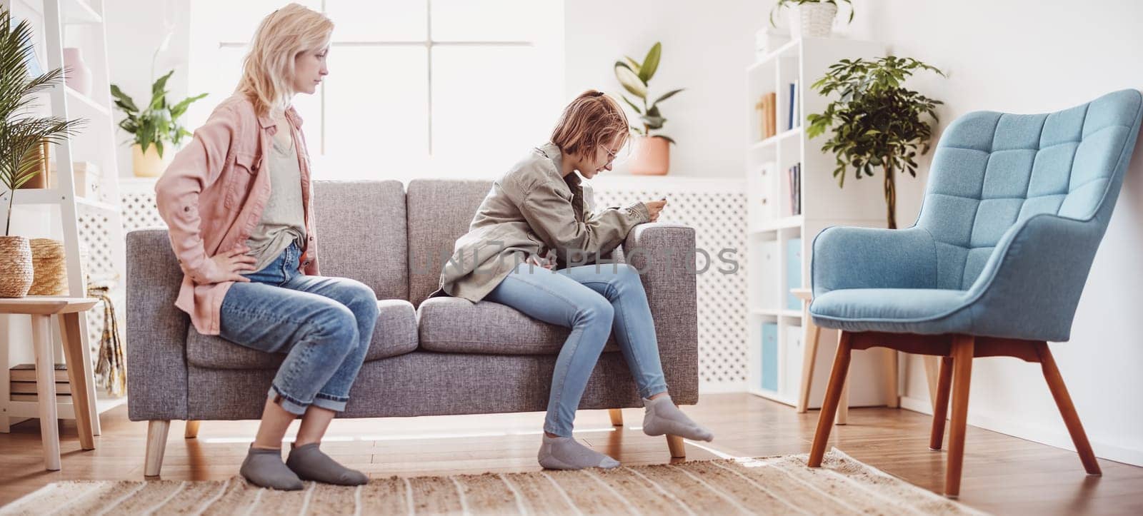Mother arguing with her daughter chatting on smartphone. Concept of the family relation.