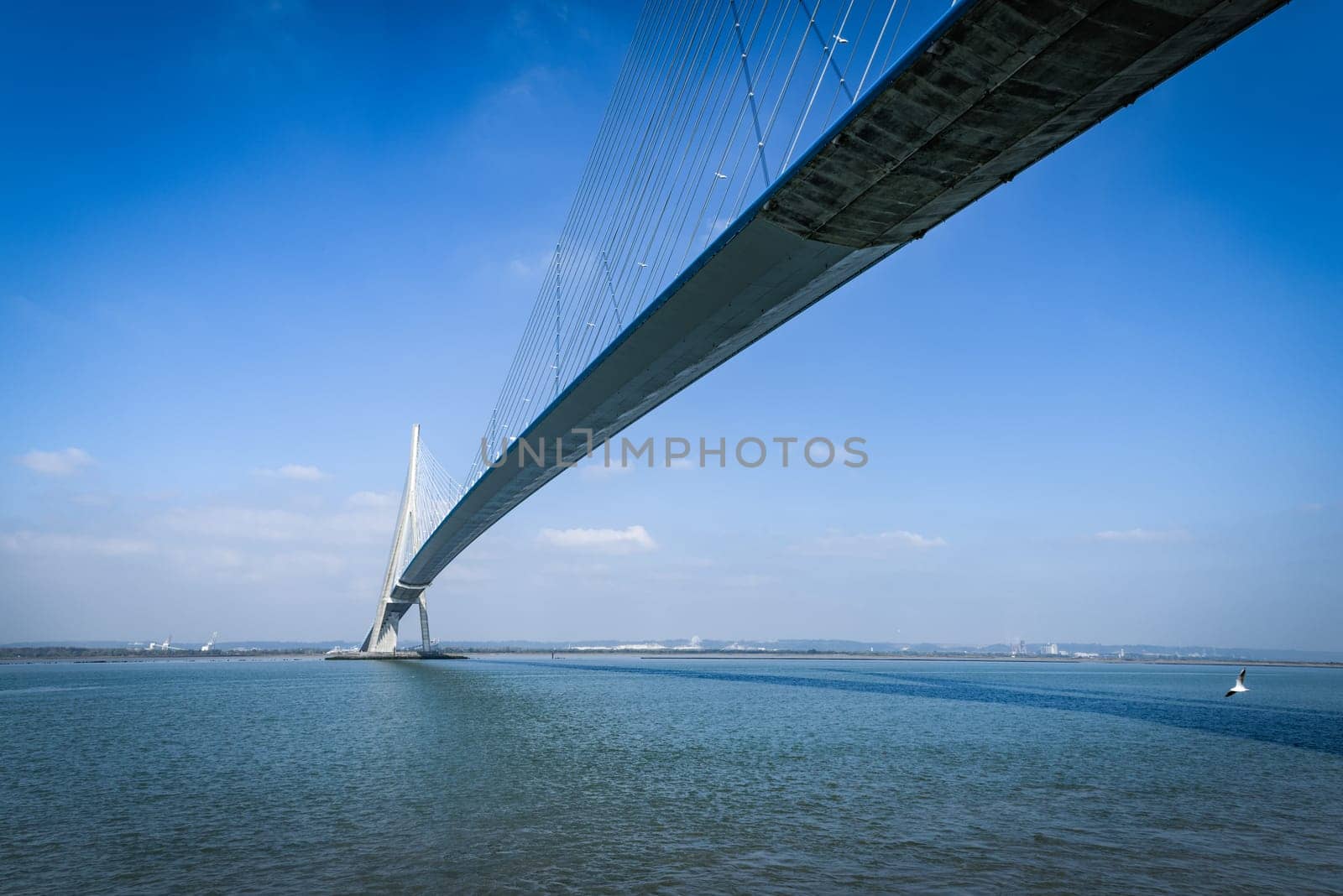 pillar of the bridge "Pont de Normandie"" reflected in the Seine river at Le Havre, France"