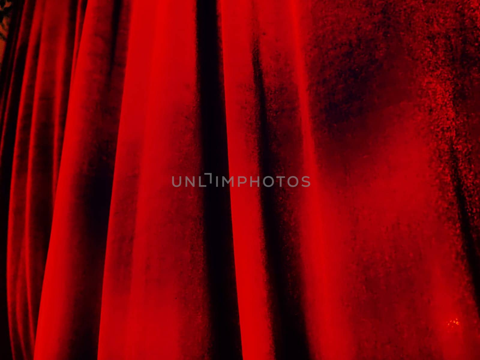 Bright red abstract background reminiscent of pleats of pleasant velvet. Stylized blurred image. Background for New Year, Christmas and Valentine's Day.