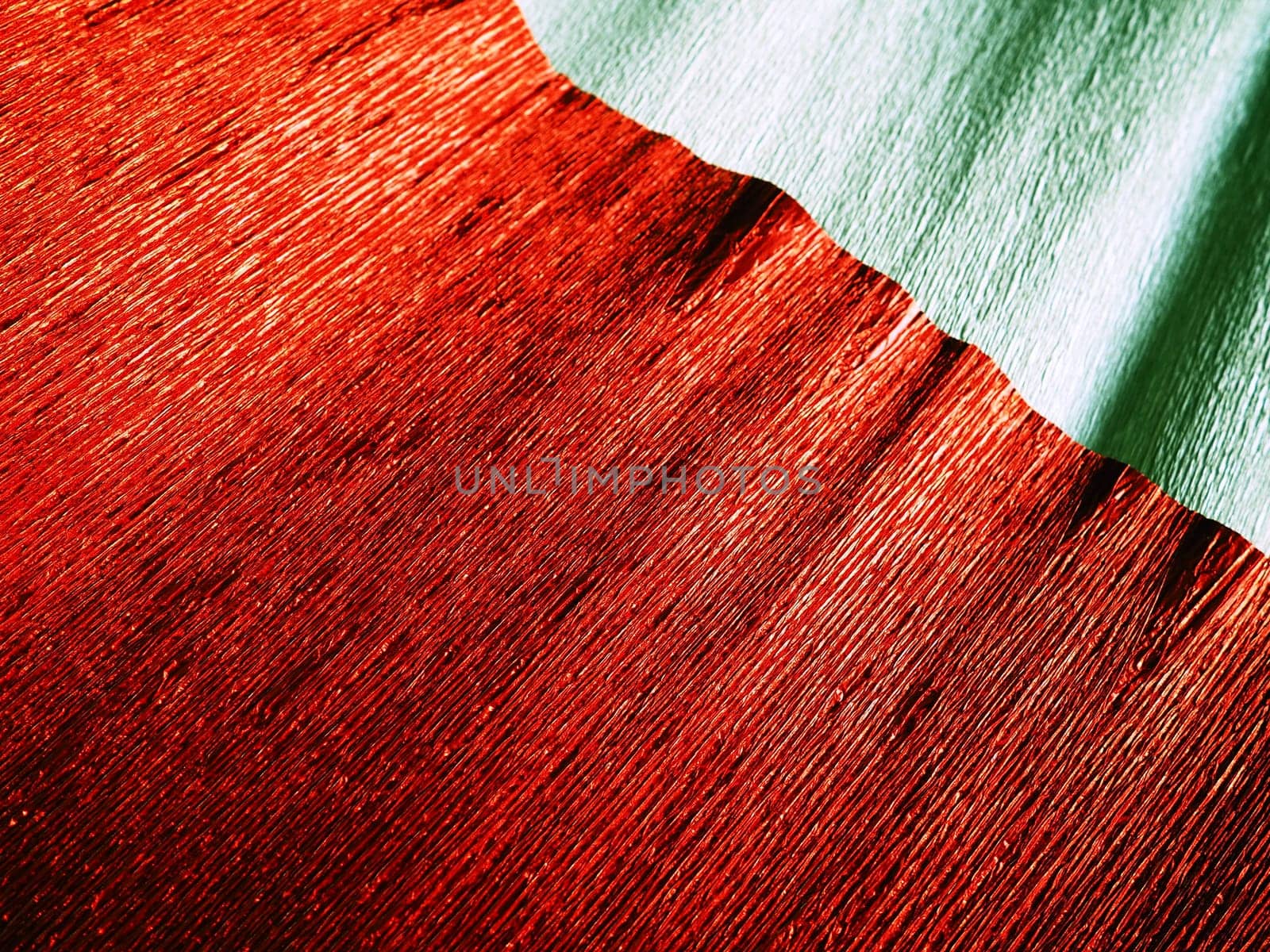 Corrugated paper in red. Uneven surface. Abstract background. Wavy edges of the paper sheet. Lighting gradient.
