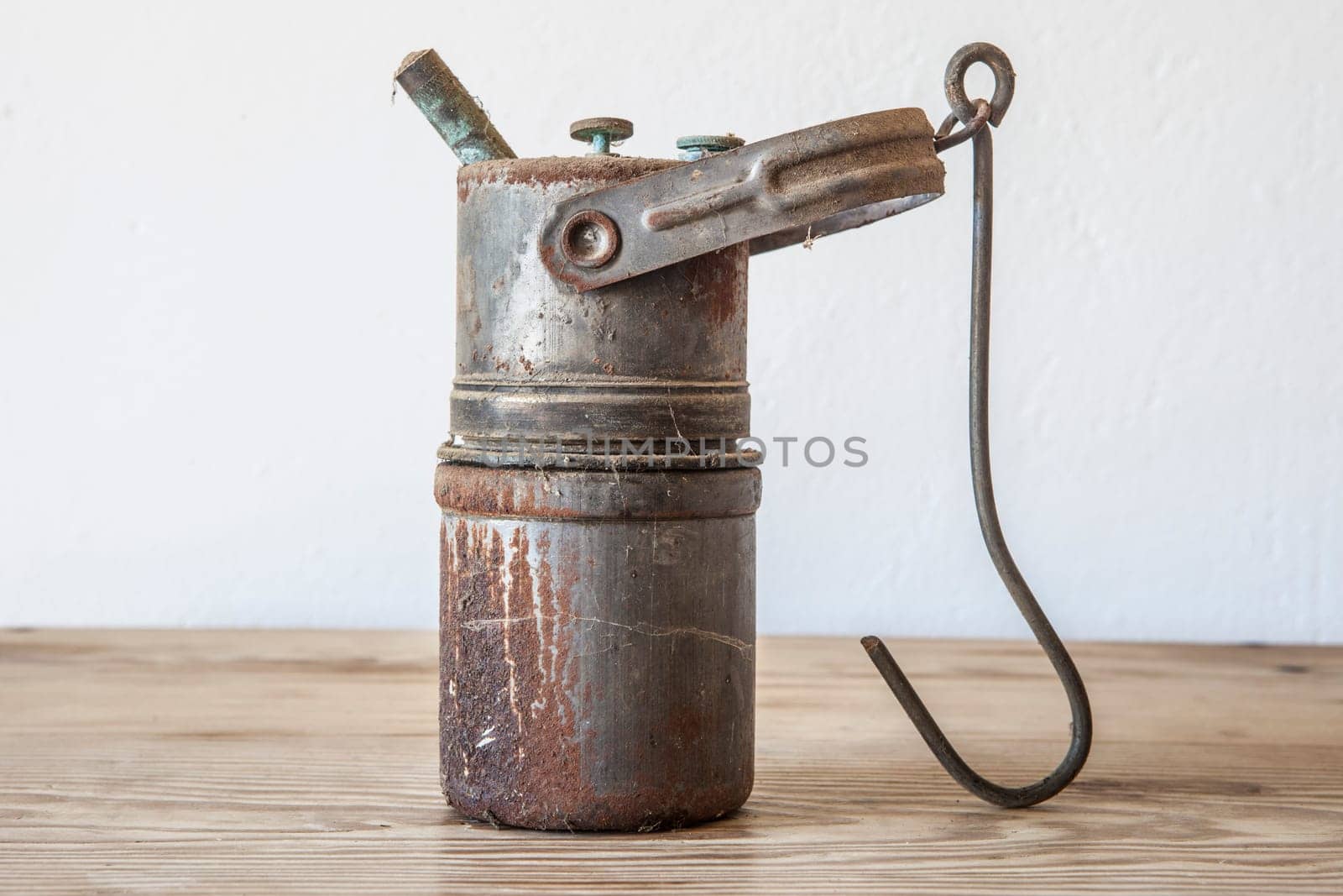 Old rusty carbide lamp. Acetylene gas lamp over wooden surface