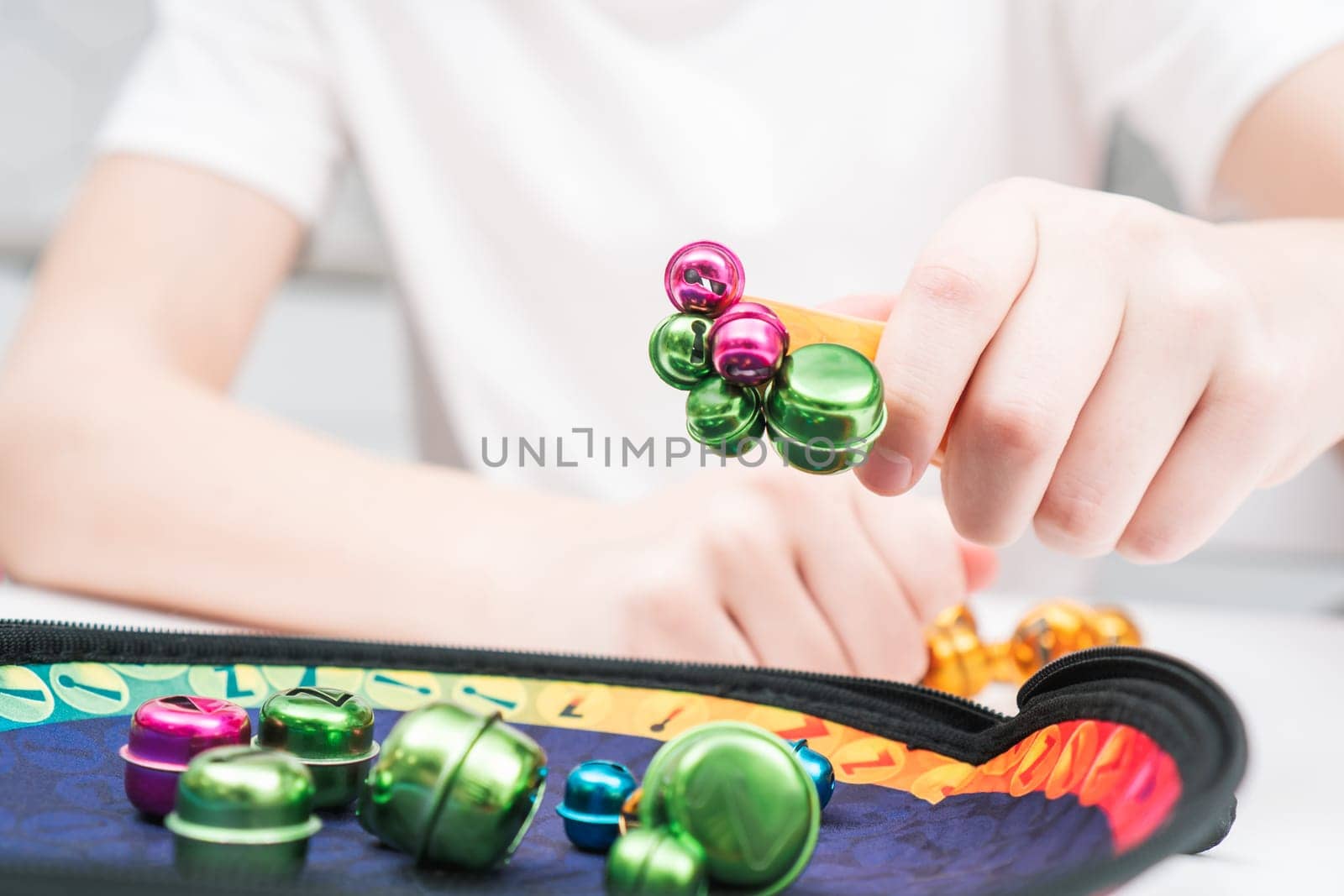 Little kid play toy sitting at table closeup. Hand of child magnetize and pick up colorful metal playthings from plate. Home leisure, funny playtime. Entertaining interesting board game.