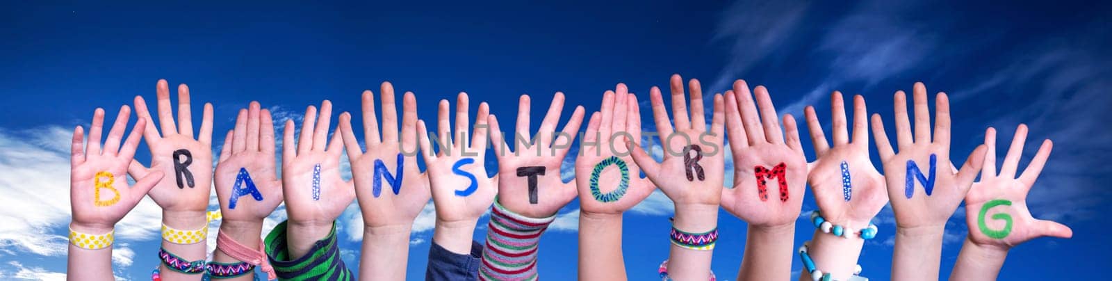 Children Hands Building Colorful English Word Brainstorming. Blue Sky As Background