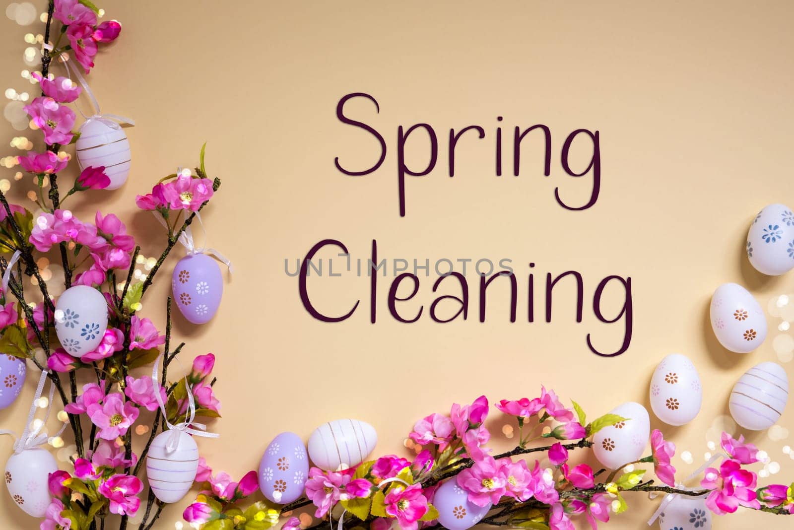English Text Spring Cleaning On Beige Background. Pink And Purple, Shiny And Bright Spring Flower Arrangement With Easter Egg Decoration.