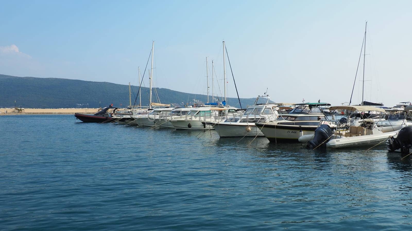 Meljine, Herceg Novi, Montenegro, August 13 2022 Boats, yachts and ships are at anchor. Moored ships in the parking lot. Adriatic Sea Mediterranean. Travel business. Sea travel and sports. Summertime