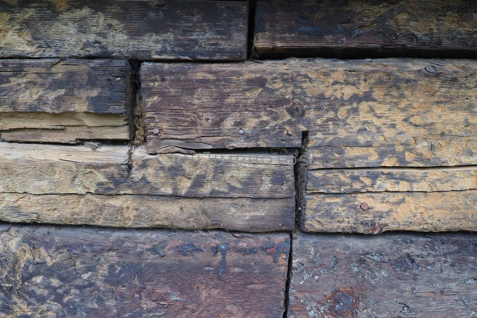 Background horizontal logs. Wooden background from shabby boards and logs. General purpose lumber. Special type of forest products. Old sleepers.