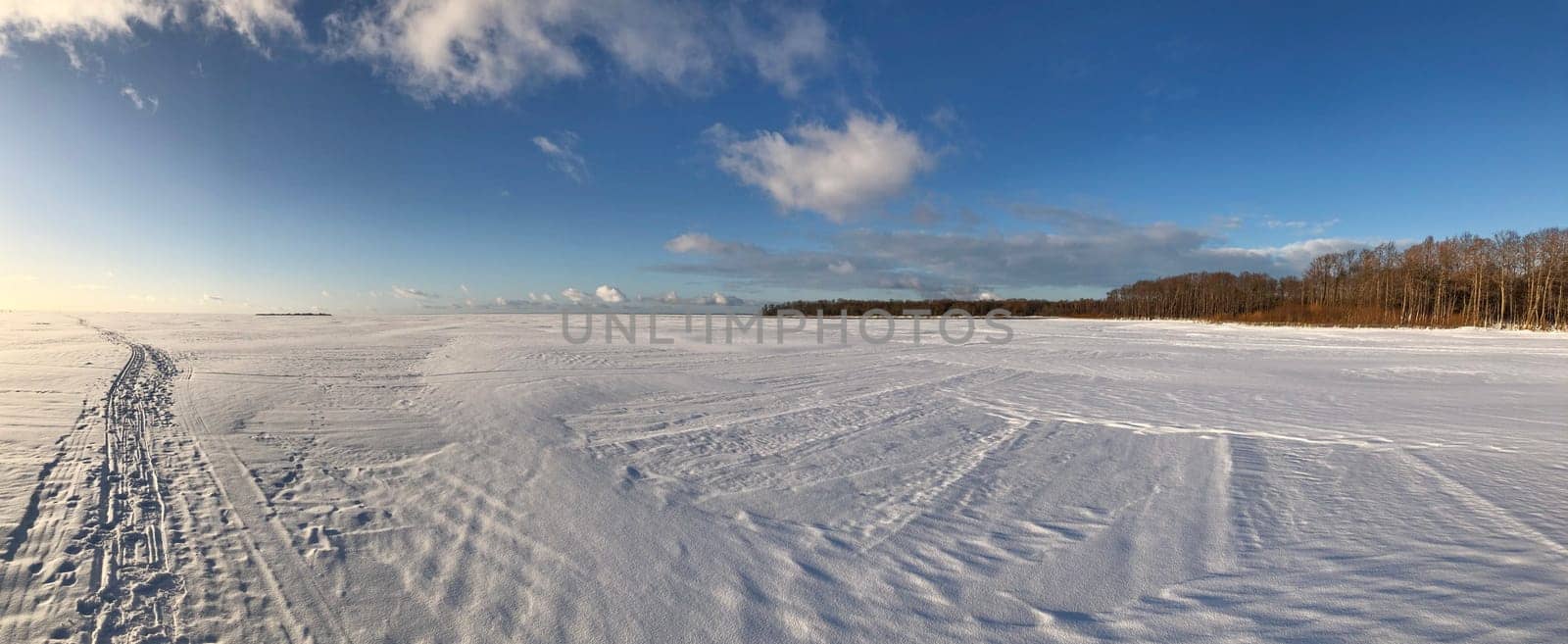 panorama frozen snow white lake, ski track, blue sky, sunny day, landscape