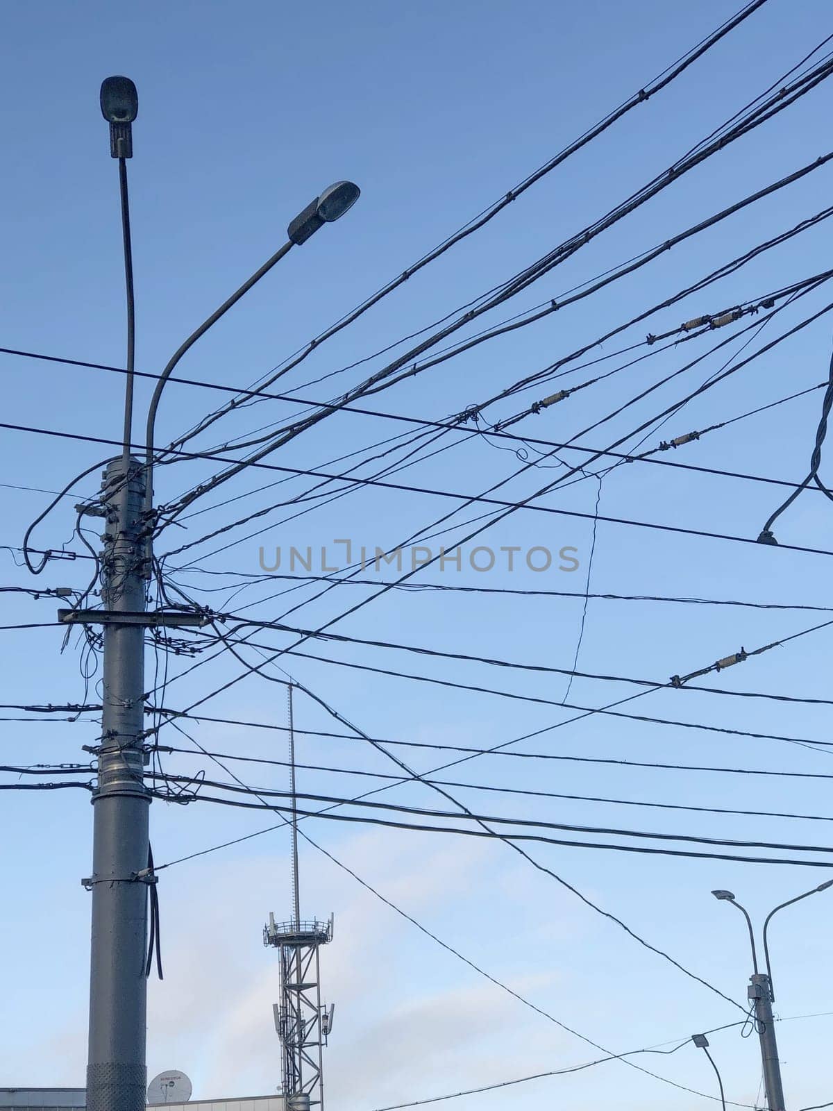 pole with many electric wires in the city sky