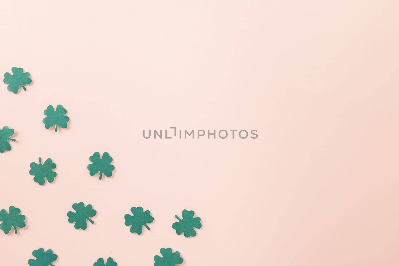 Happy St Patricks Day decoration background. above top view of paper clover leaves festive decor, shamrocks leaves holiday symbol with copy space on colour background, Banner greeting card concept