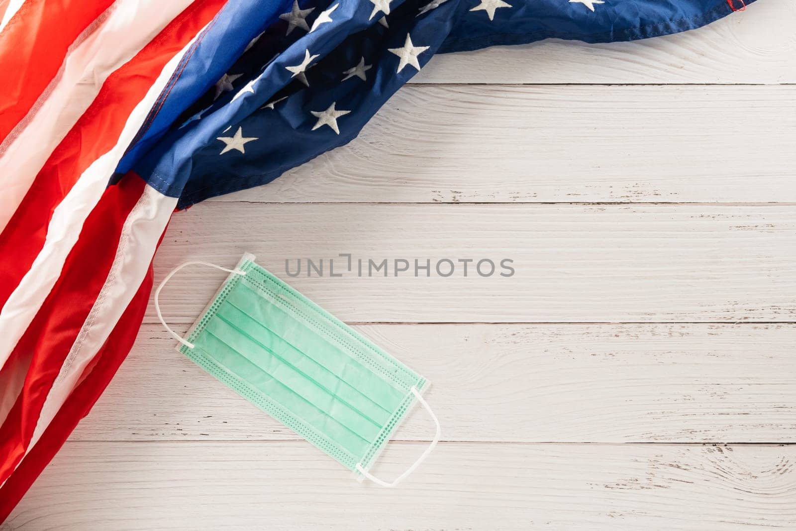 Happy presidents day. flag of United States America with copy space, Top view USA flag and face protection for coronavirus on white wood background board, banner design, Patriot Day, COVID-19