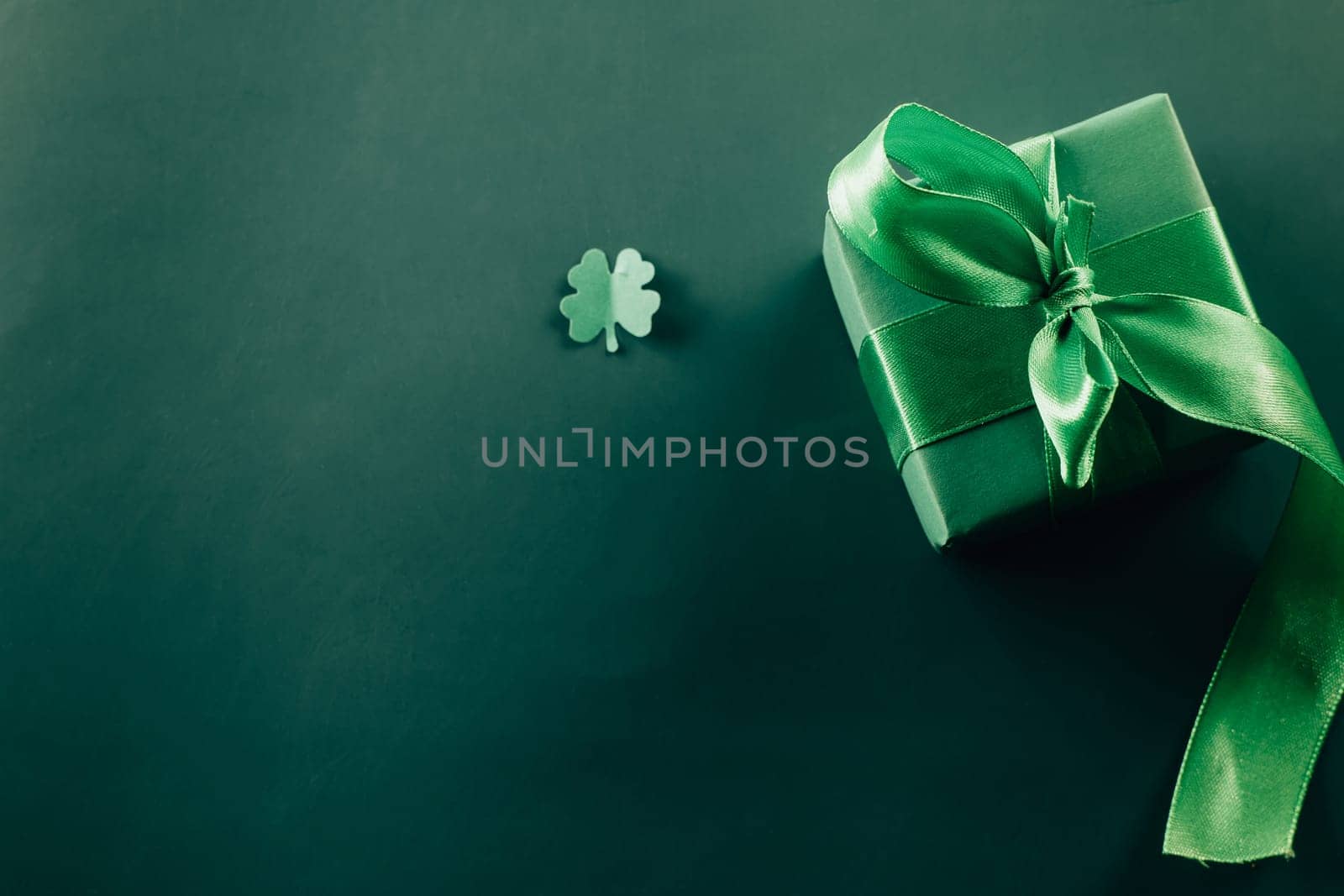 Happy St Patricks Day decoration background. above view gift box green clover leaves festive decor, shamrocks leaves holiday symbol with copy space on green background, Banner greeting card concept