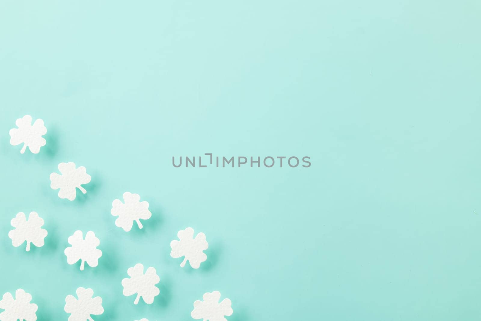 Saint St Patrick's Day. Top view flat lay of paper cut clover leaves festive decor, shamrocks leaf holiday symbol with copy space on colour background, Banner greeting card good lucky concept