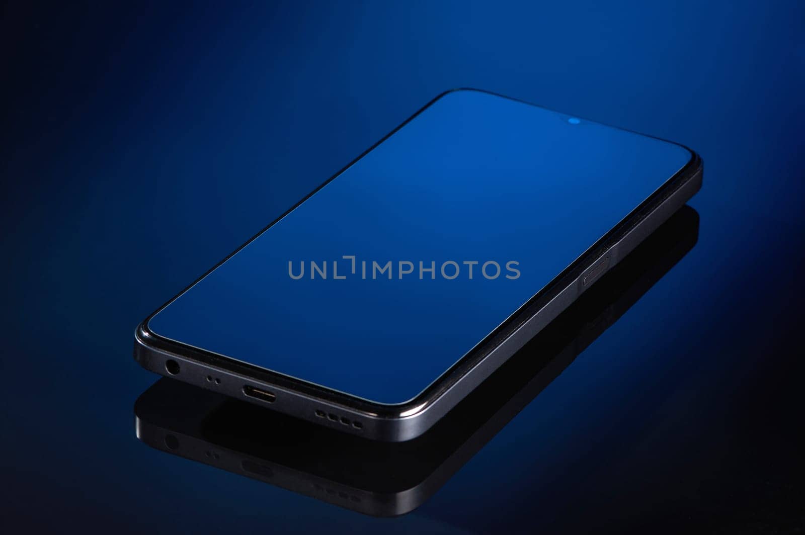 the smartphone is lying on a glass surface. High quality photo