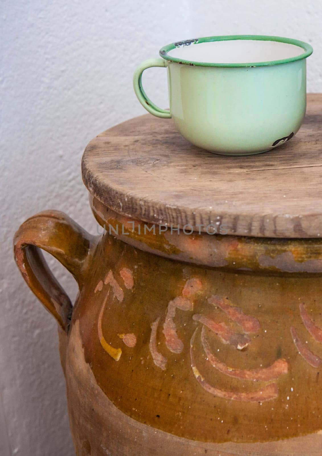Large earthenware jar with enamel ware for drinking water. Old Cottage kitchen concept