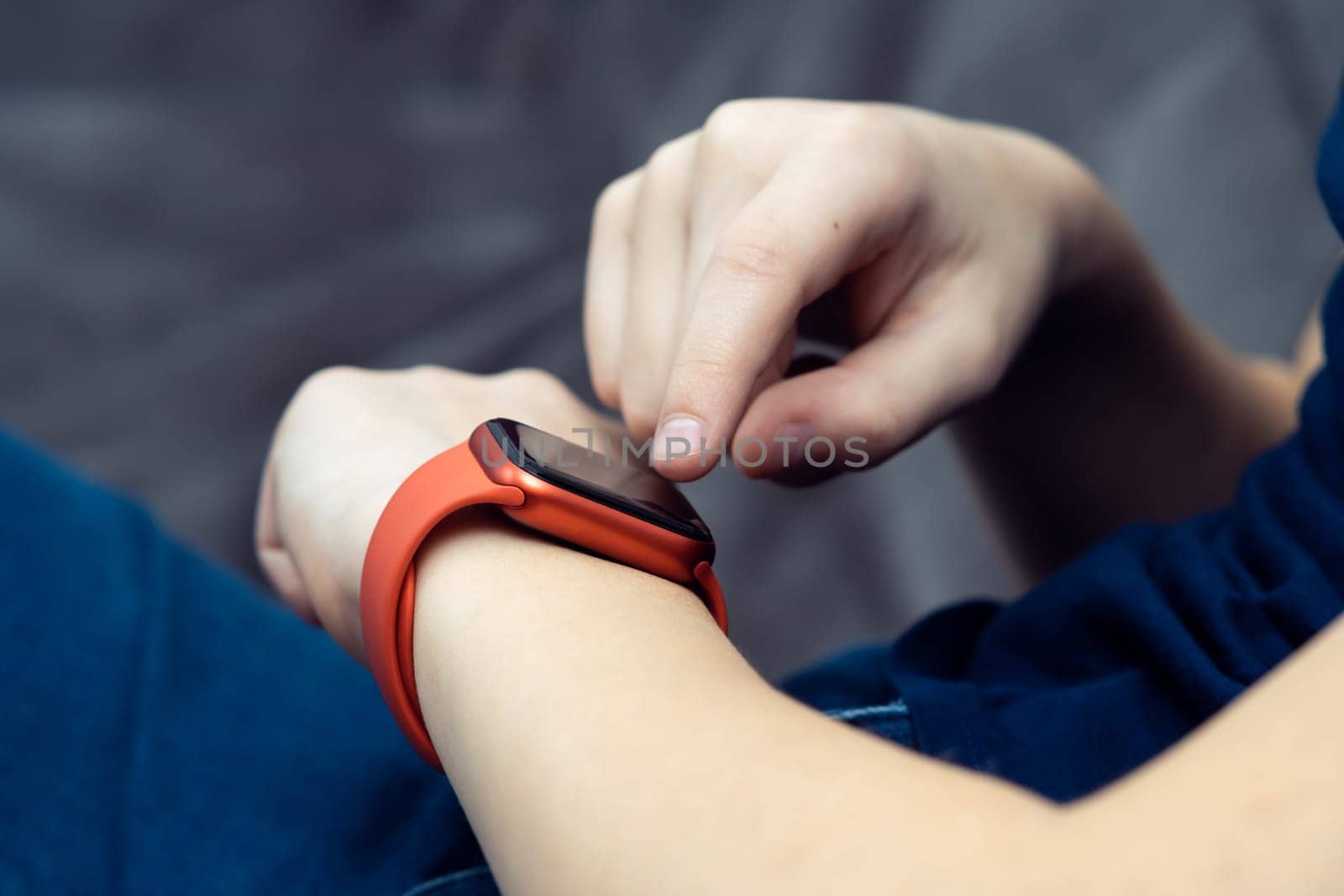 Close up cropped man hand with red Wireless smart watch, electronic gadgets, wrist watch technology. Pulse checking, fitness tracker and cardiogram, ecg application. Clock and Bluetooth technology