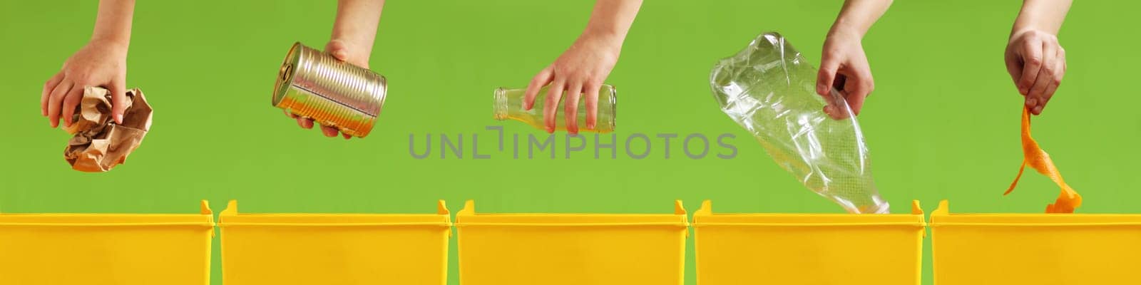 Children's hands throw paper, metal, glass, plastic, organic garbage into different yellow containers on a light green background. Waste sorting. Environment care. Recycling and ecology concept.