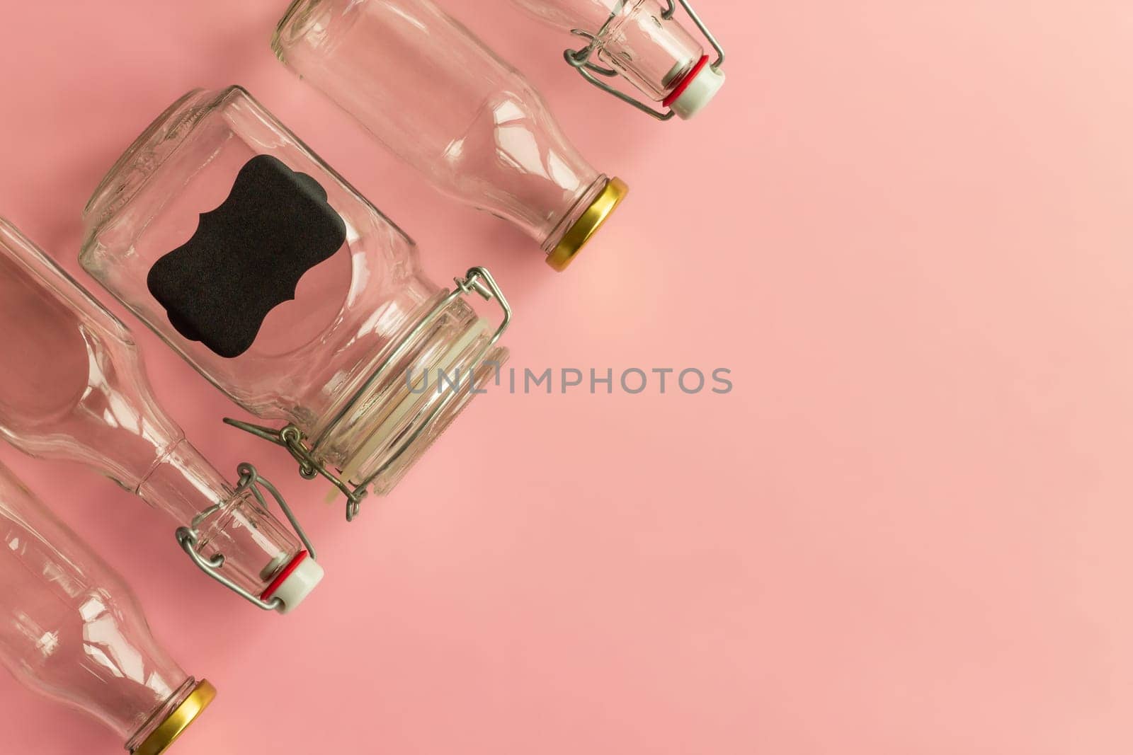 Glass bottles and jars on a pink background. Zero waste and ecological concept. Top view. Copy space.