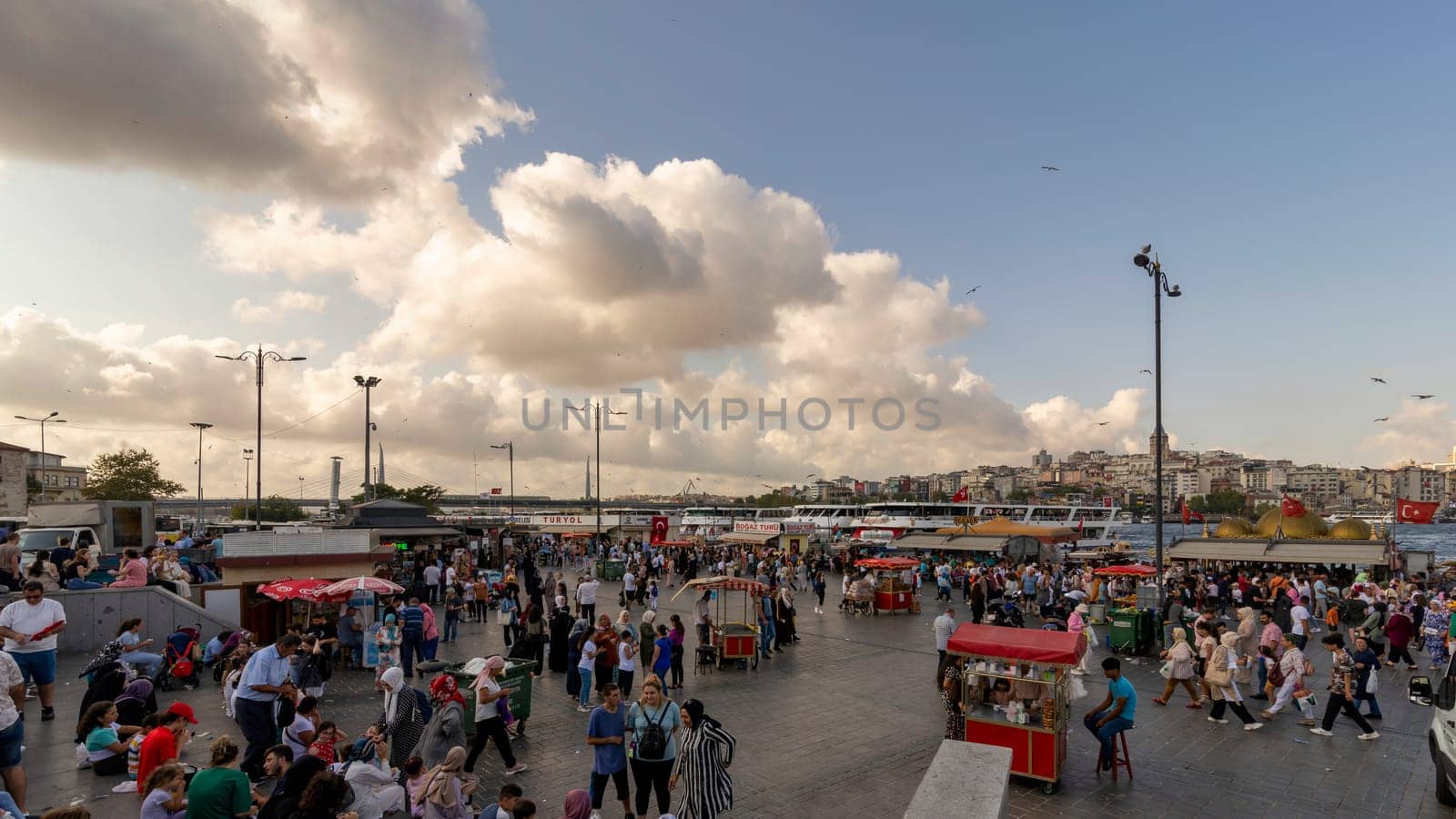 Istanbul, Turkey - August 30, 2022: Crowds of local citizens at Eminonu Plaza during the Victory Day holiday with background of Istanbul city view
