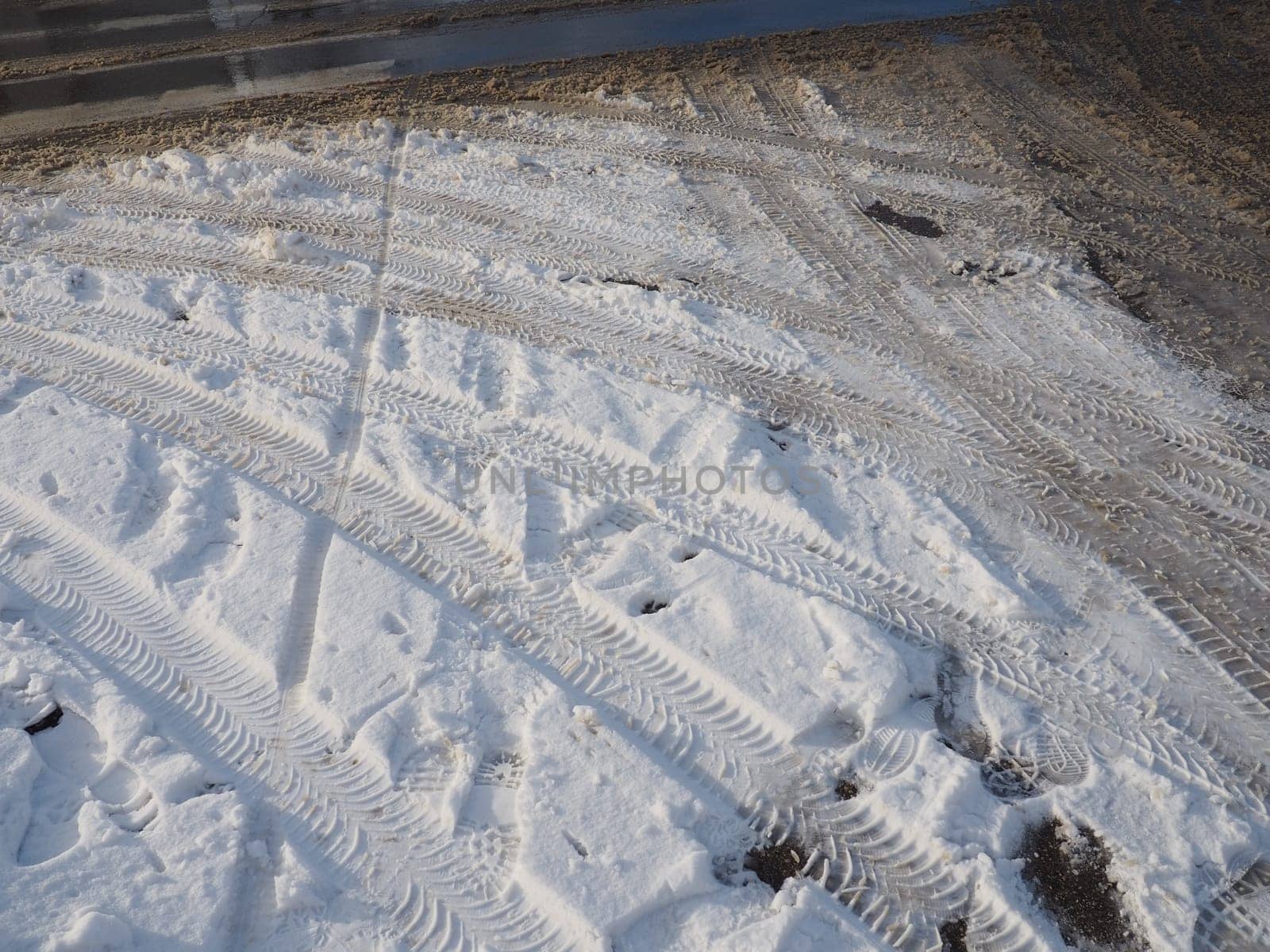 A fork or siding from a roundabout. Snowdrifts on the side of the road. Bad weather and traffic. Snow on asphalt. Difficult driving conditions. Winter slosh on the road. Braking distance of a car.